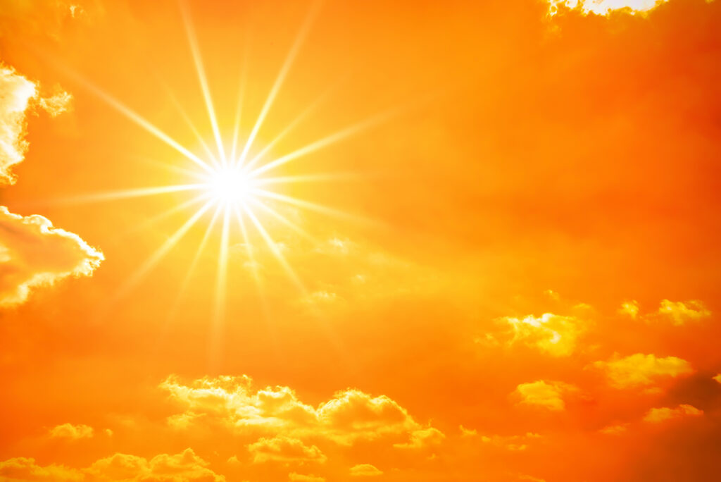 Sonne an orangenem Himmel mit wenig Wolken